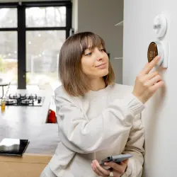 Kobieta zmieniająca temperaturę na Smart Home